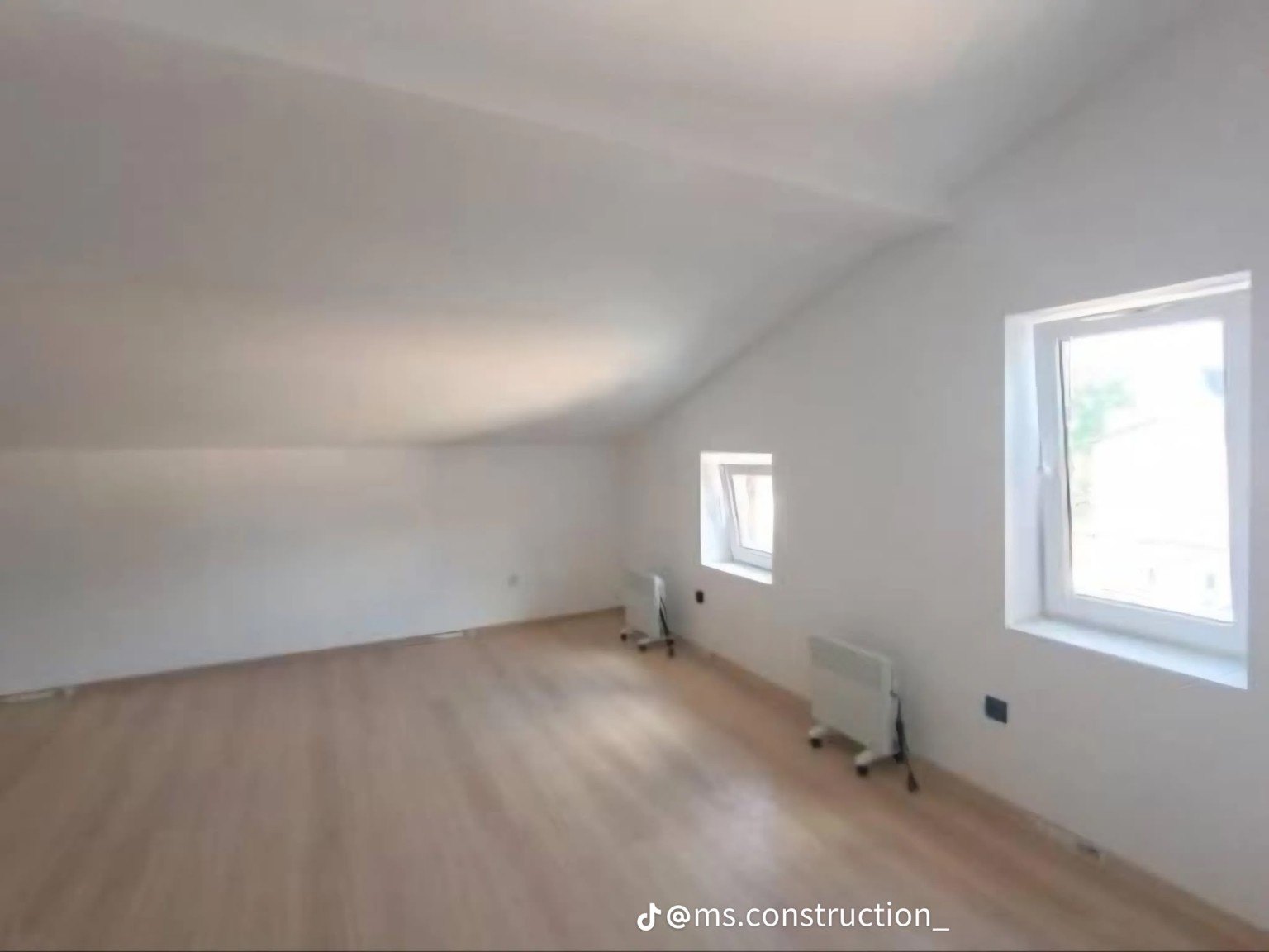 Attic interior with light flooring and two windows