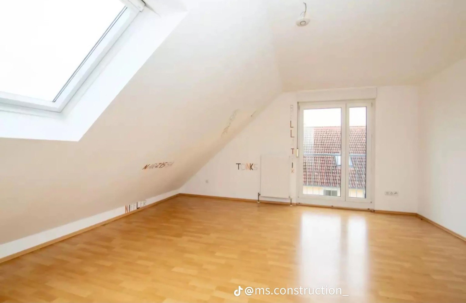 Attic room with roof window and glazed doors