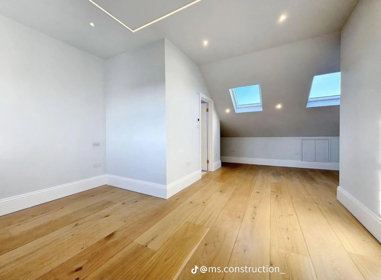 Attic interior with roof windows and recessed lighting