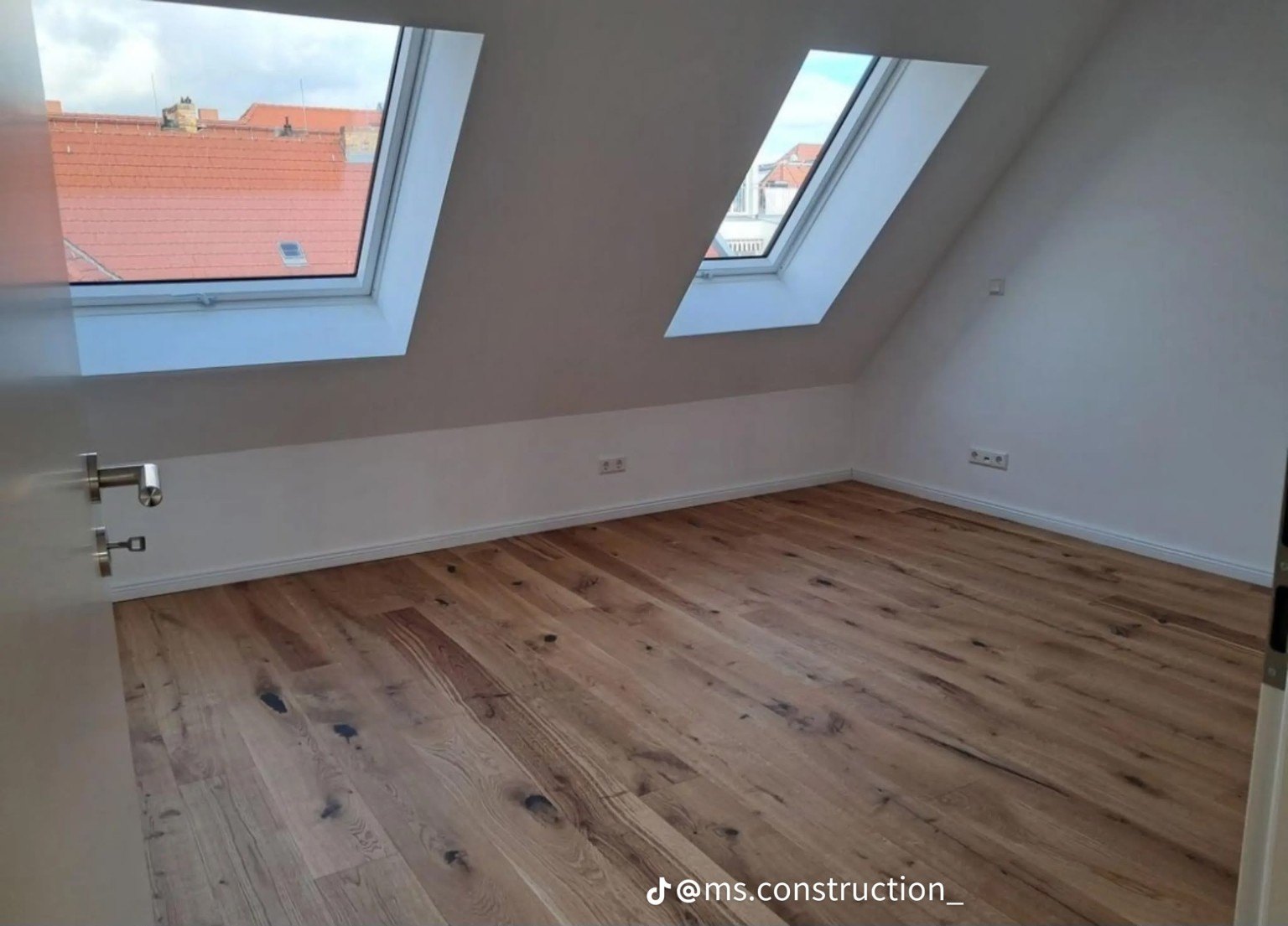 Attic room with two roof windows and timber flooring