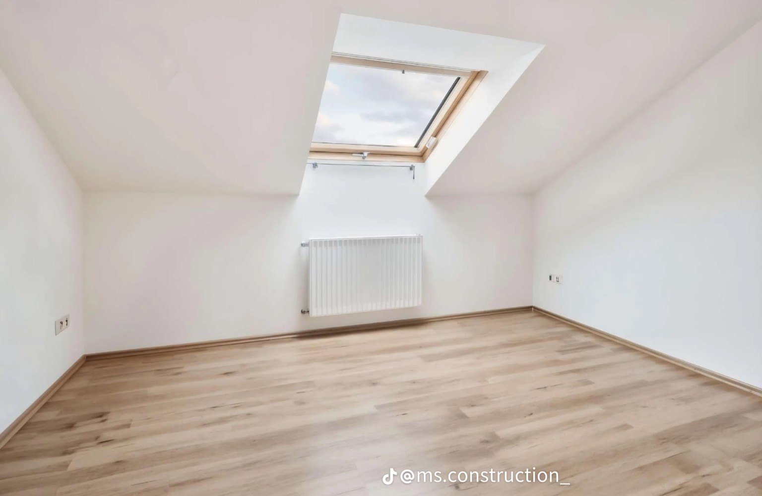 Attic room with roof window and radiator