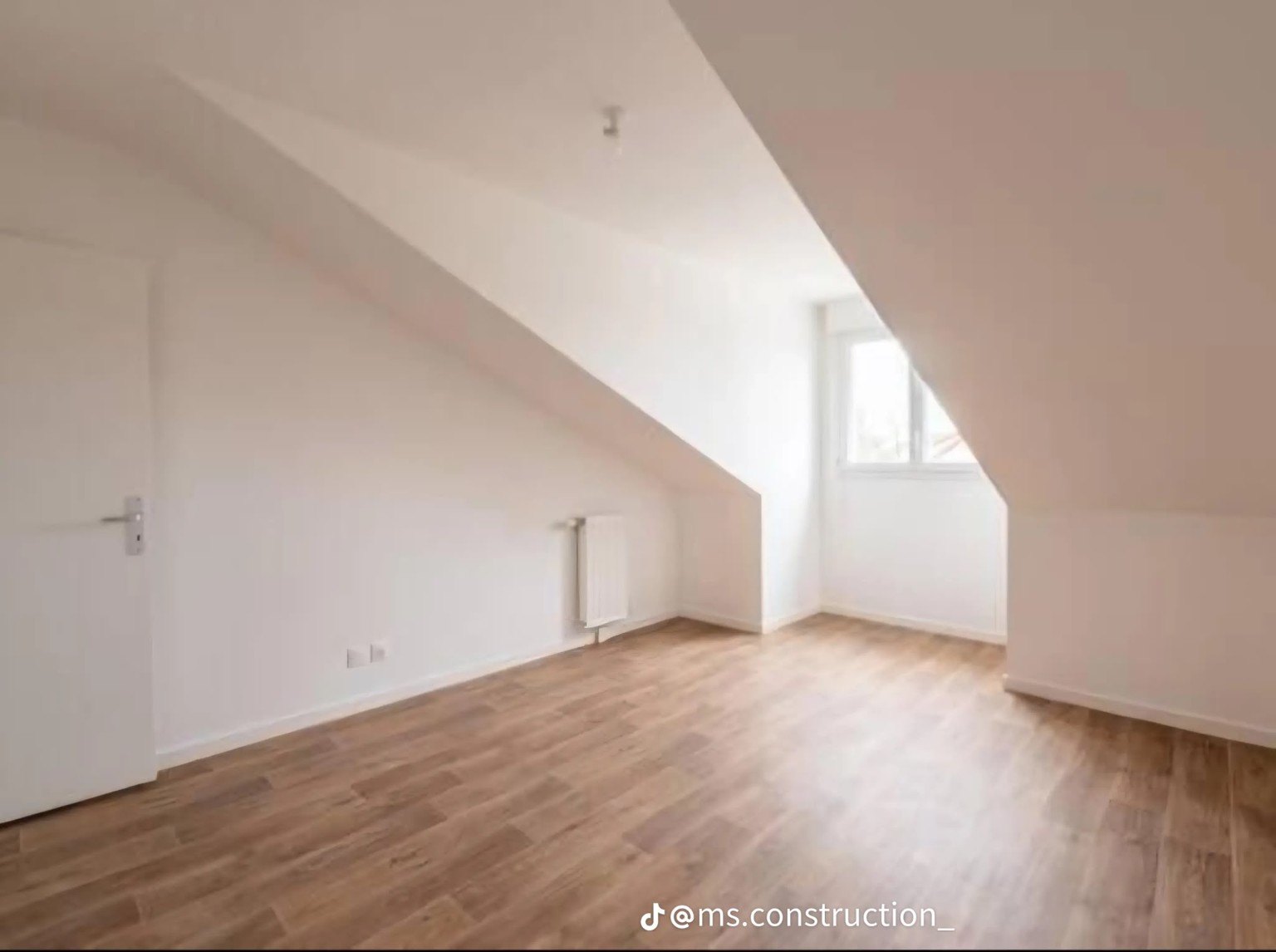 Attic room with light flooring and dormer window