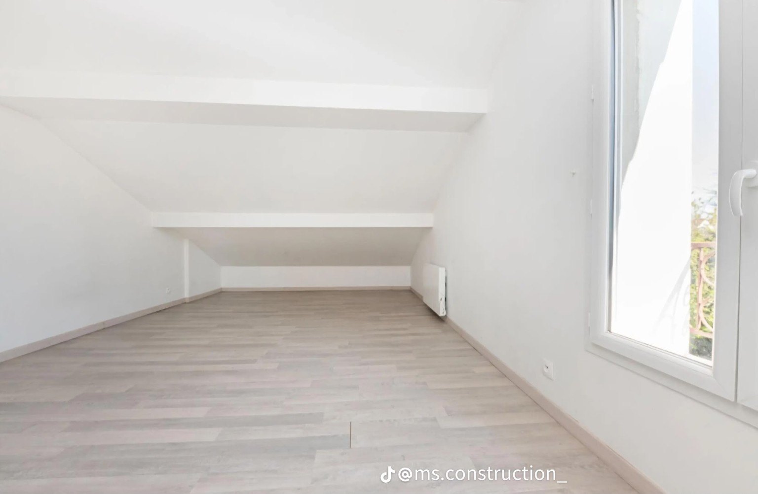 Long attic room with pale flooring